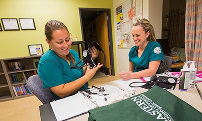 Two nursing students practicing blood pressure readings.