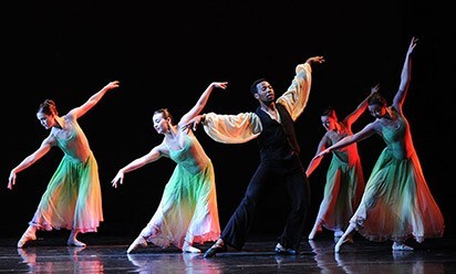 a group of student dancers in color clothing performing on stage