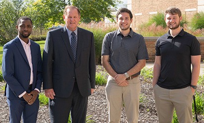 Alumnus Steve Klotz, second from left, stands outside with COB students on campus.
