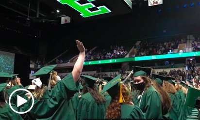 group of graduates in green gowns
