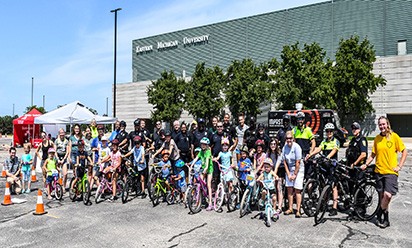 A large group of participants from a previous year's Bike Rodeo pose by their bikes