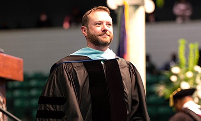 Regent Marques Thomey wearing regalia in a commencement ceremony.