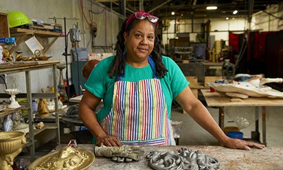 Dr. Joey Quiñones in an art studio space with sculptures