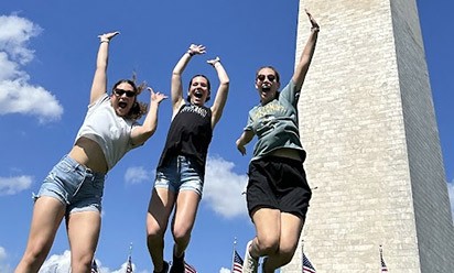 Jenna Tarzwell in Washington with fellow TWC students jumping in front of the Washington Monument.