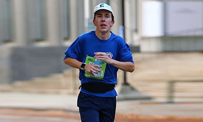 Hugh Thorp runs in a marathon wearing EMU hat.