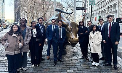 Finance students stand by the Bull of Wall Street statue.