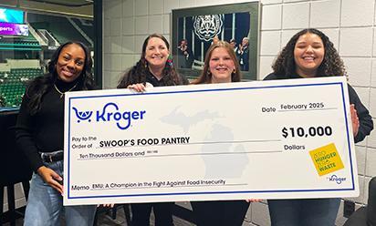 Students hold a large check from Kroger for $10,000 for Swoop's Pantry.