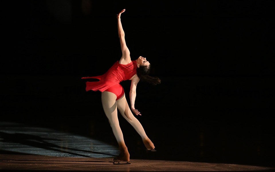 Skater Heaney in a red dress performing on the ice.