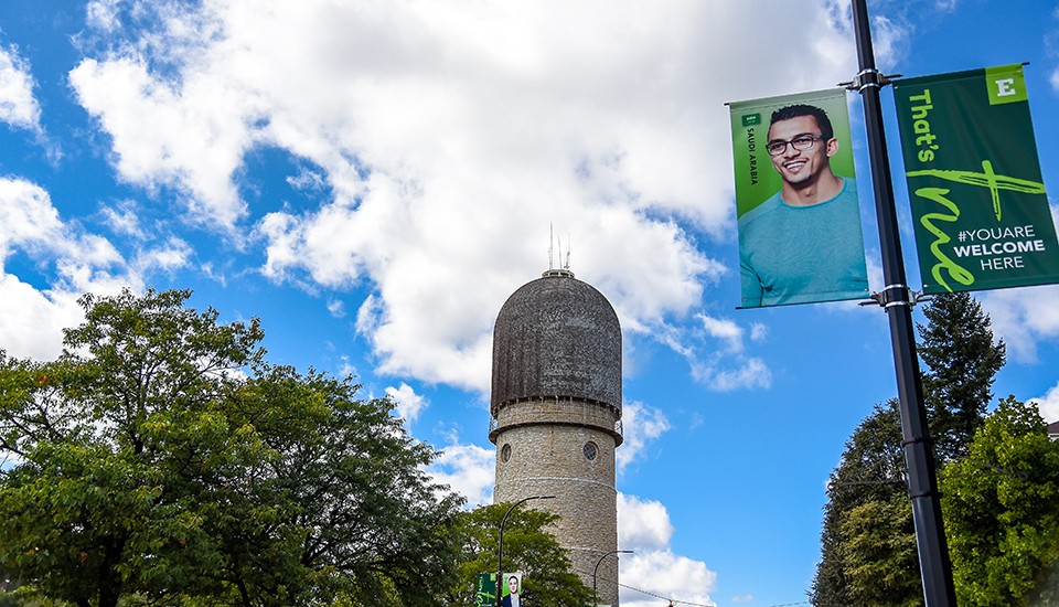 The Ypsilanti Water Tower and a banner featuring EMU international student on a sunny day.