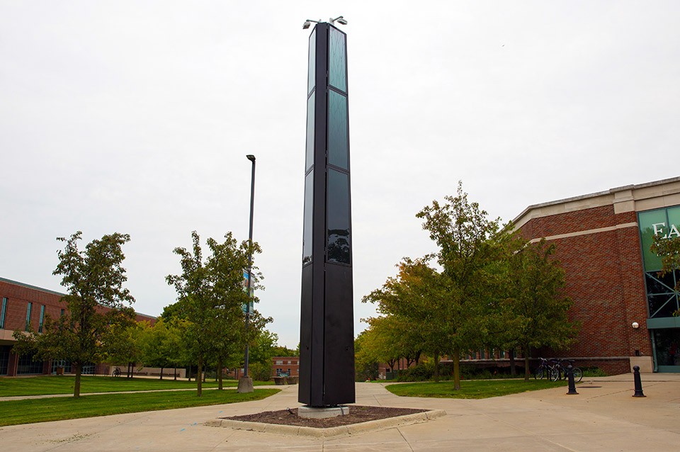 Tall black Verizon cell phone tower stands outside of Marshall Hall on campus.