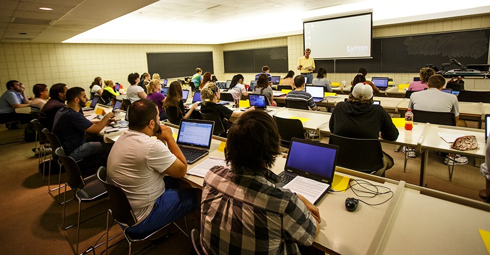 A professor teaches a finance class full of students.