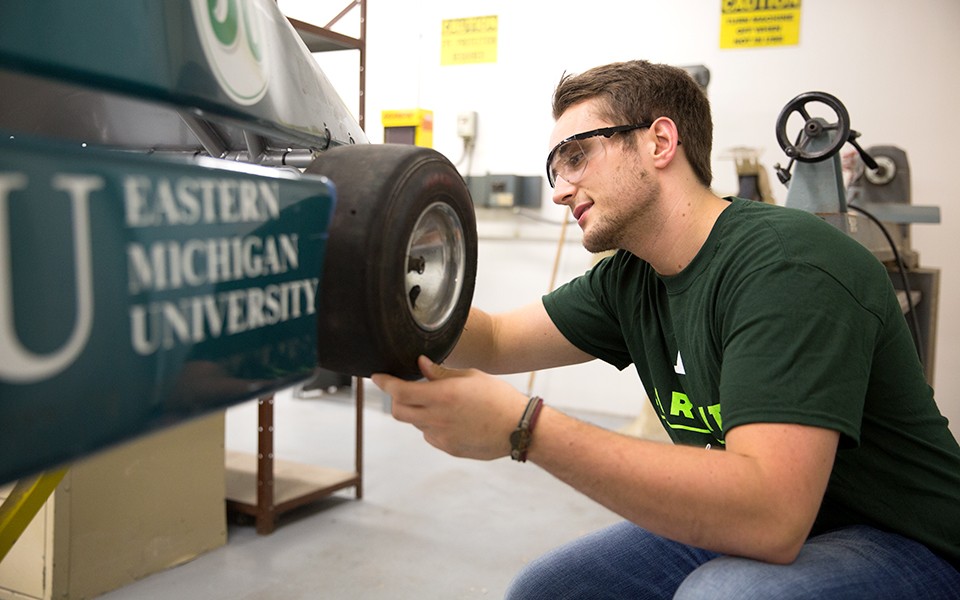 An EMU student working on a vehicle in a COT classroom.