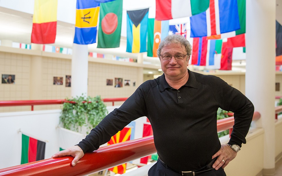 David Victor at the EMU School of Business Owen building by the international flags