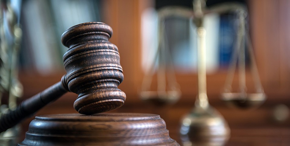 Image of a gavel and the scales of justice in a courtroom