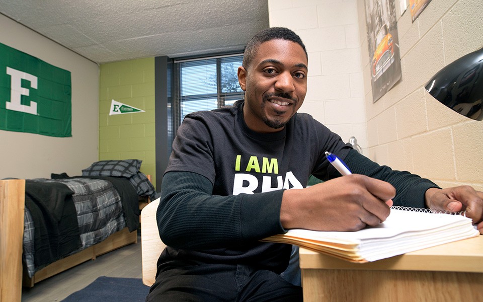 A student works at his desk in a dorm room