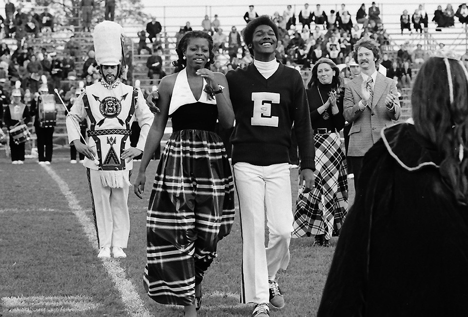 Fans cheer the 1972 EMU Homecoming Queen on the football field