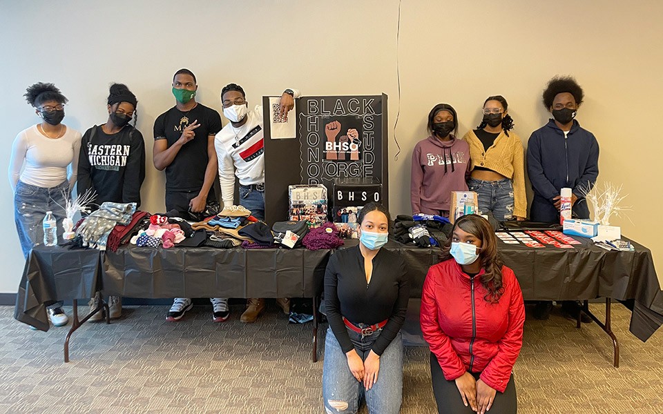 Black Honors Student Organization (BHSO), wearing face masks, stand by a table piled with donations at their recent event.