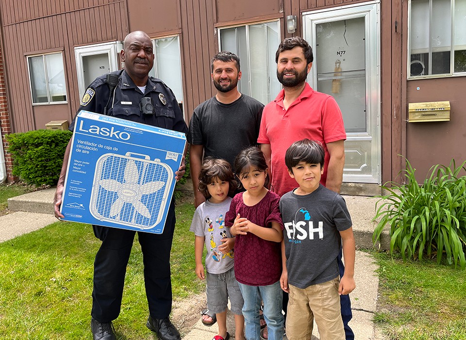 EMU Police Officer Patrick McGill provides an Afghan family with a fan to cool their apartment.