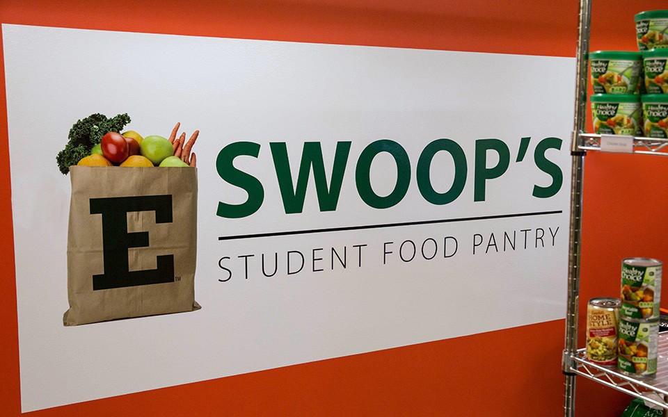 Shelves of canned goods by the Swoop's Food Pantry sign at Pierce Hall.