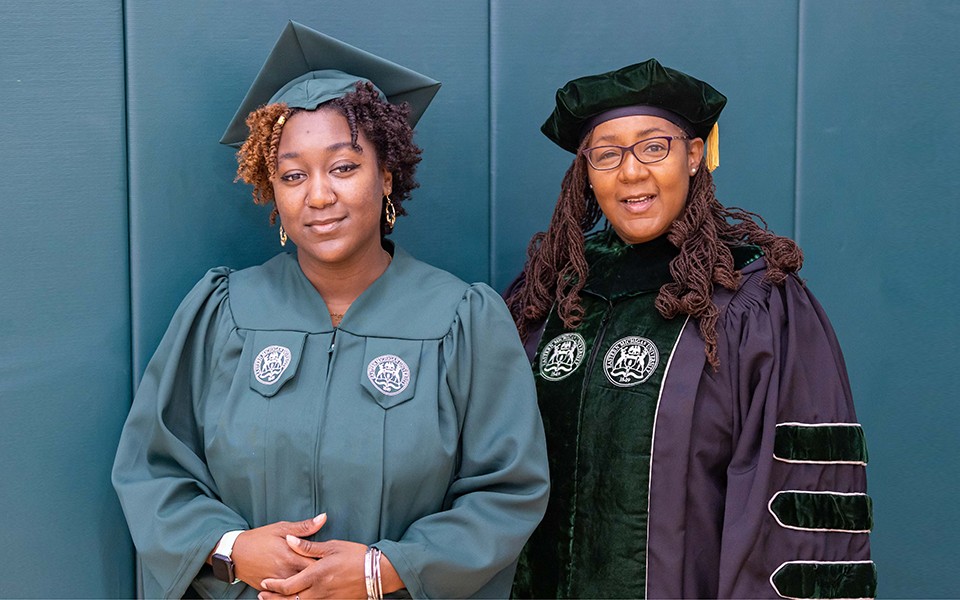 Kyra Brown, and her mom, Dr. Kimberly Brown, stand together in their commencement regalia at the Summer Commencement Ceremony.