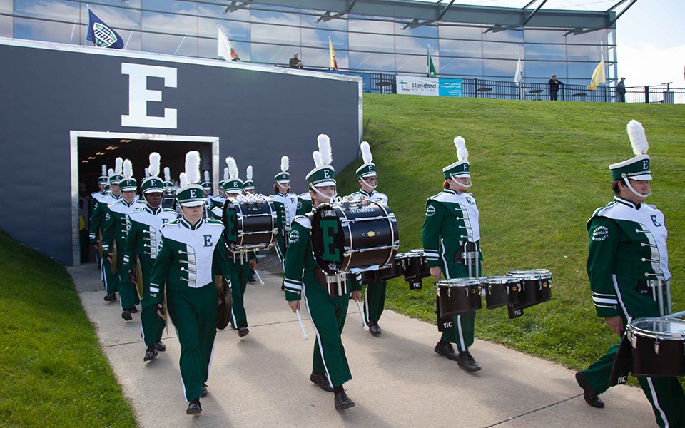 The EMU Marching Band enters the football field through the tunnel.