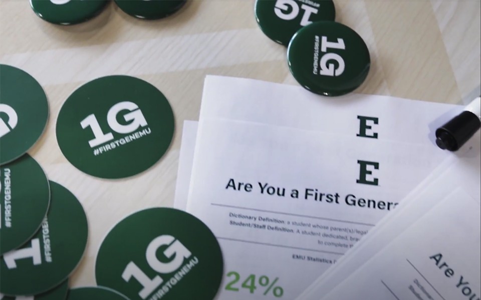 1G buttons, stickers and handouts on a table for a First Generation Day event.