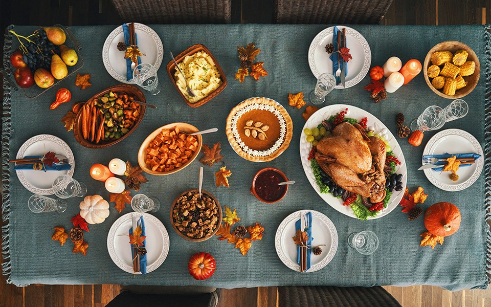 An overhead view of a festive table filled with traditional Thanksgiving fare.