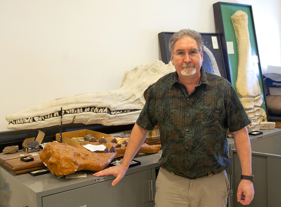 Steve LoDuca stands beside some large fossils and bones