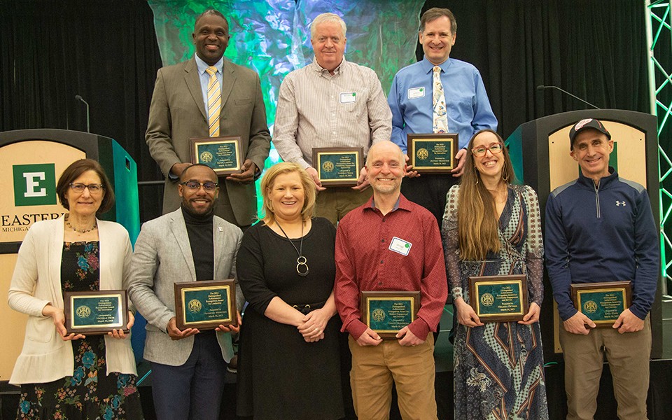 Winners of the 2023 distinguished staff achievement recognition awards hold their plaques in the Student Center Ballroom.