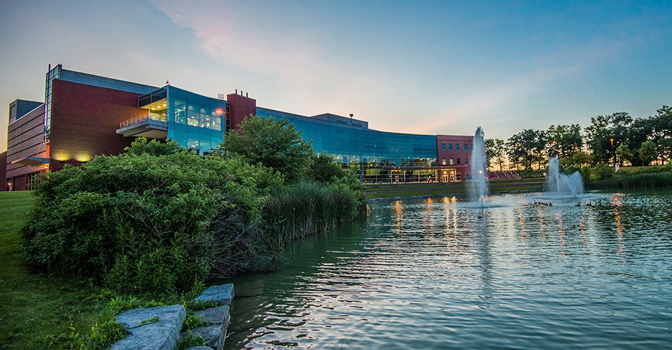 Exterior photo of the Student Center at dusk, viewed from across the pond.
