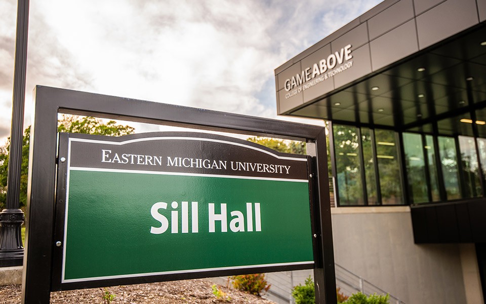 Close-up view of Sill Hall sign and GameAbove College of Engineering and Technology in the background