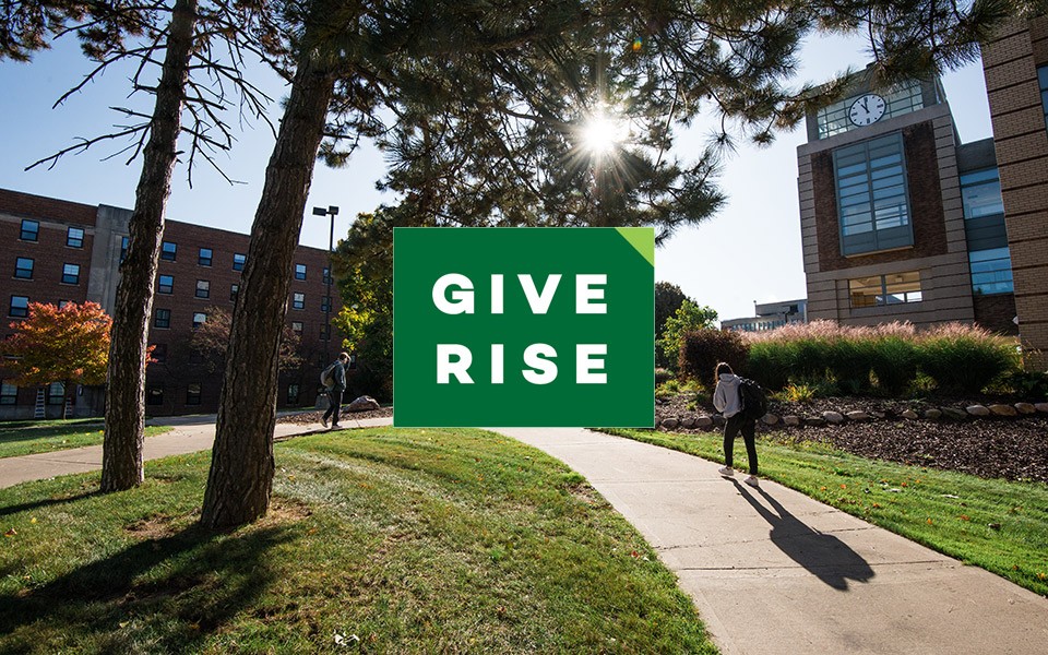 The Give Rise logo on a photo of students walking by Halle Library with sun streaming through the trees.