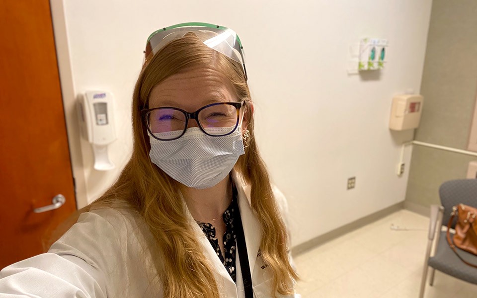 Jennifer Battles wearing PPE take a selfie in a healthcare setting in the field of clinical psychology.