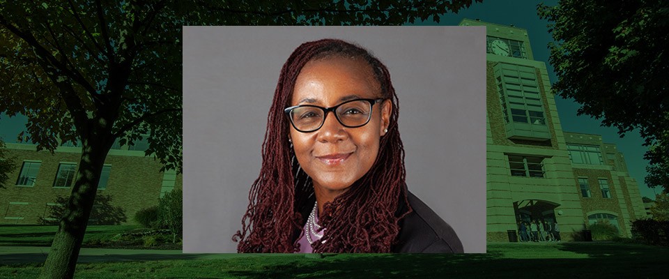 Dr. Kimberly J. Brown's headshot on a background photo of central campus.