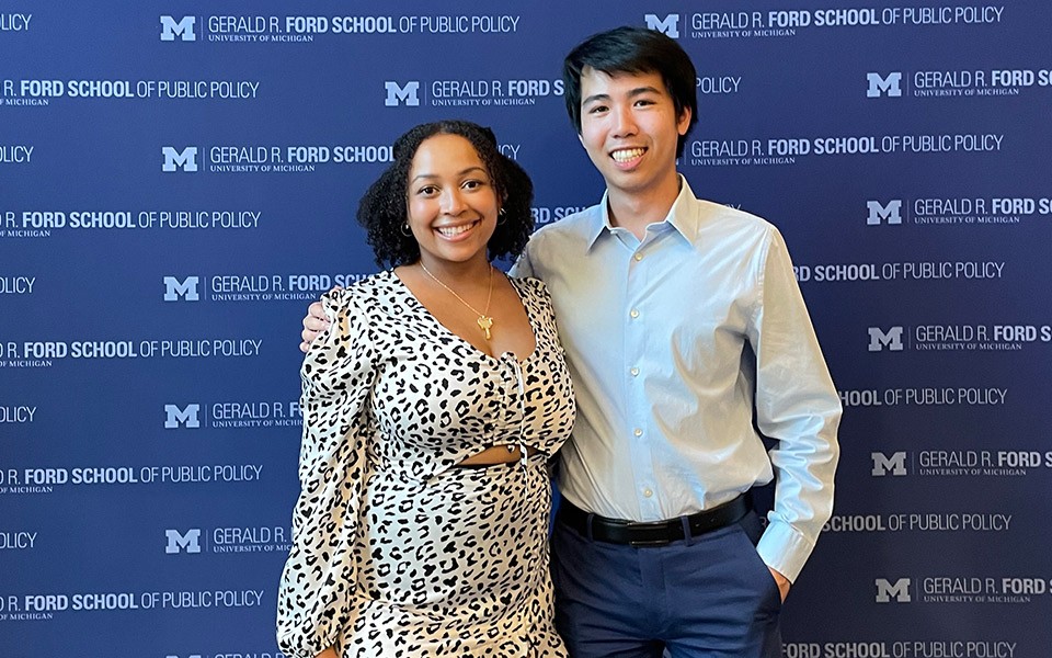 Makaiya Snead and Jeffrey Hoang in front of a U-M Gerald R. Ford School of Public Policy banner.