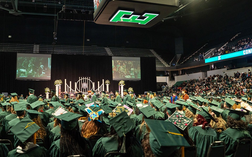 A sea of mortarboards are seen from behind at the George Gervin GameAbove Center at a commencement ceremony.