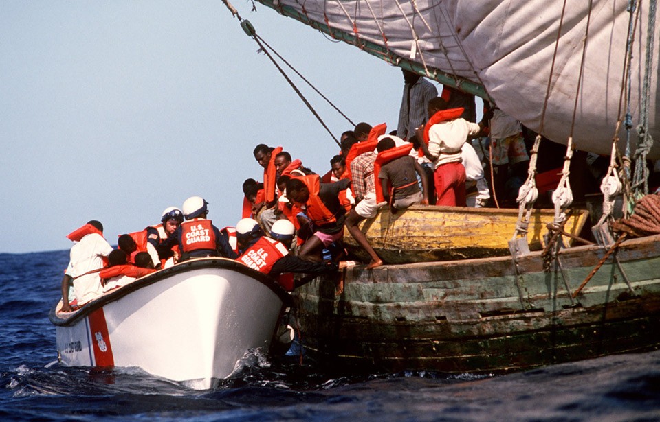 Haitian refugees board a Coast Guard boat.