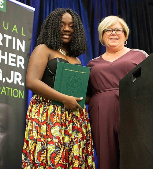 Nailah Bush, left, receives her award from Donna Holubik, director of financial aid.