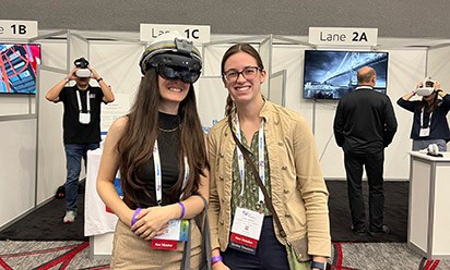 Haylee Haik, wearing VR goggles, and Kara Bishop at the conference.