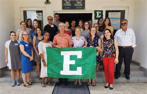 TESOL students and faculty pose in Montenegro with an EMU flag.