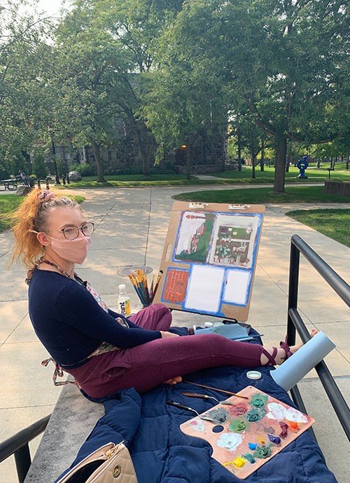 art student painting outside on campus