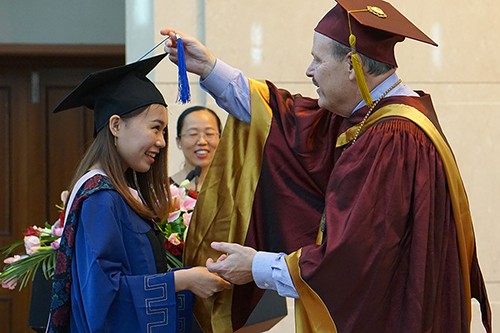 President Smith congratulates a grad at Tianjin University of Commerce in China.